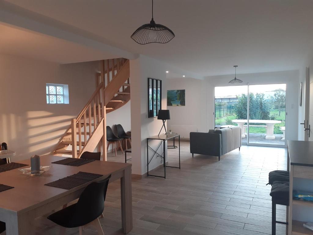 a living room with a staircase and a table and chairs at Le Gambetta in Flixecourt