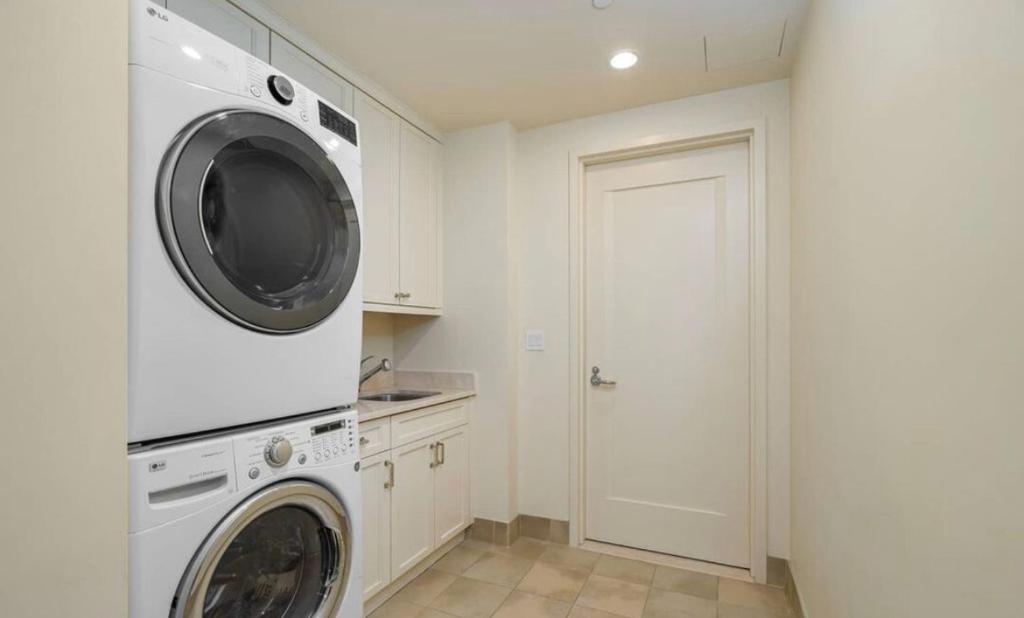 a white laundry room with a washer and dryer at Luxury apartments in Los Angeles