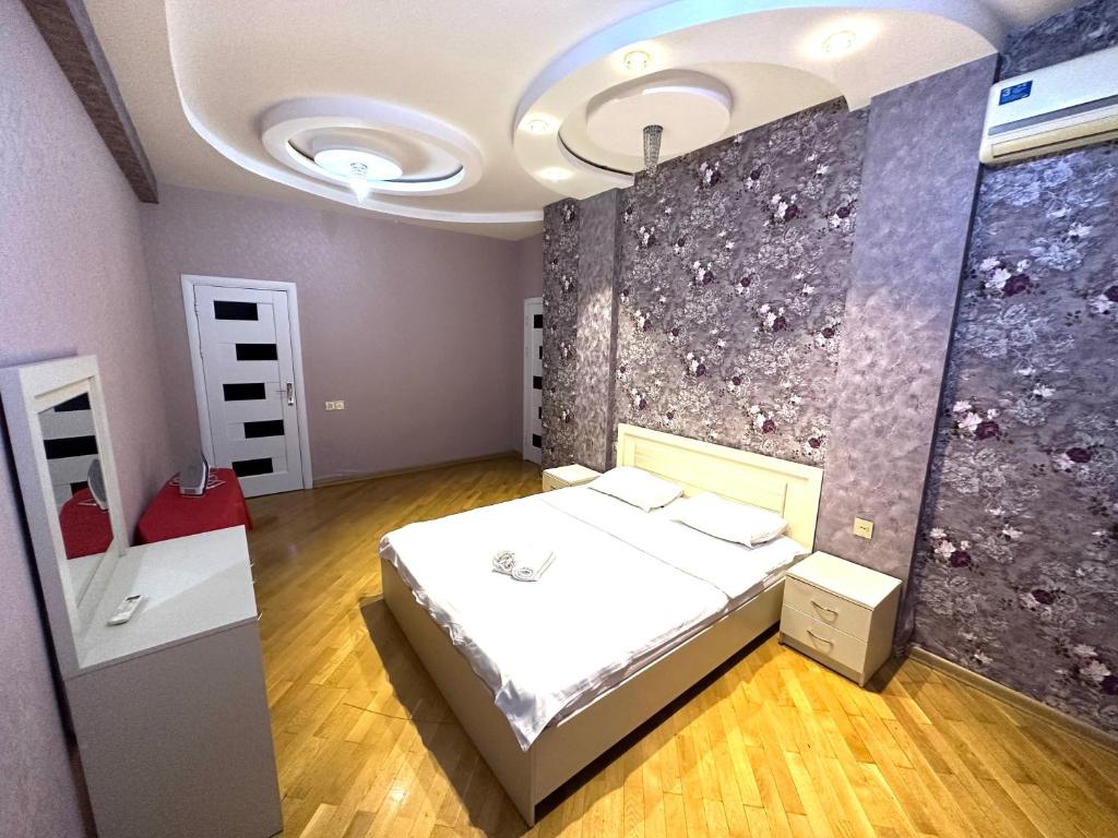 een kamer met een bed en een muur met bloemen bij Xatai cozy apartment by Baku Housing in Baku