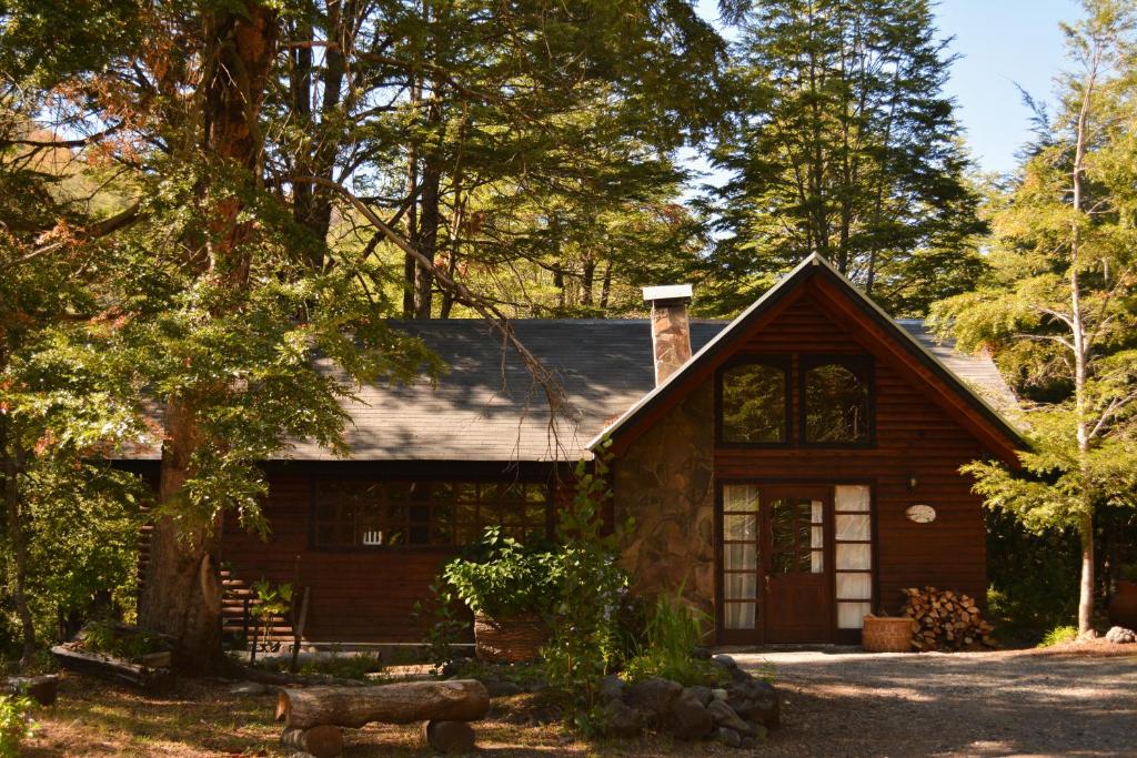 una cabaña en el bosque con un árbol en Cascadas del Llaima, en Refugio Llaima