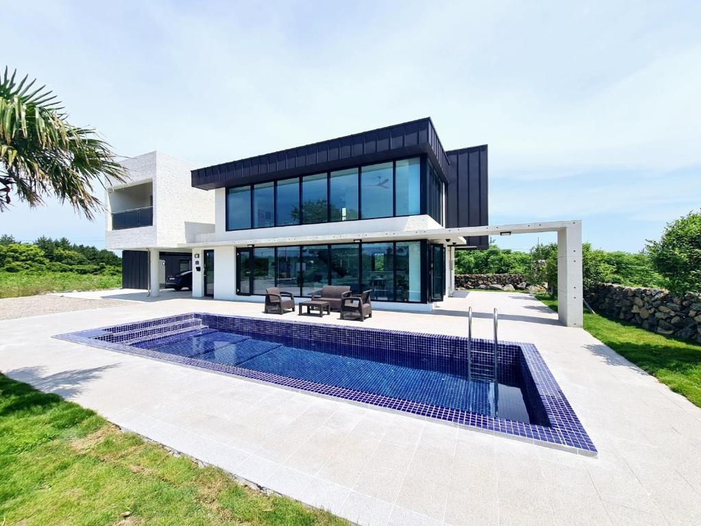 a house with a swimming pool in front of it at Almare Woljeong in Jeju