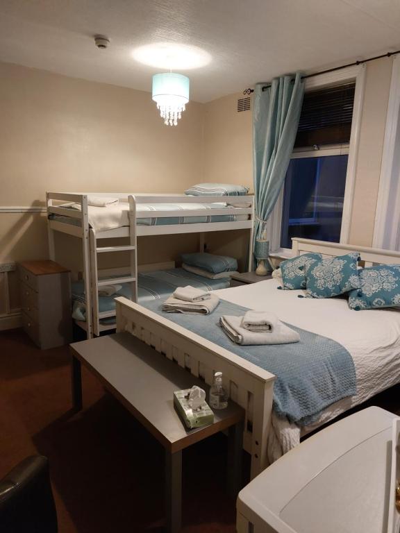 1 Schlafzimmer mit 2 Etagenbetten und einem Schreibtisch in der Unterkunft Lynbar guesthouse in Blackpool