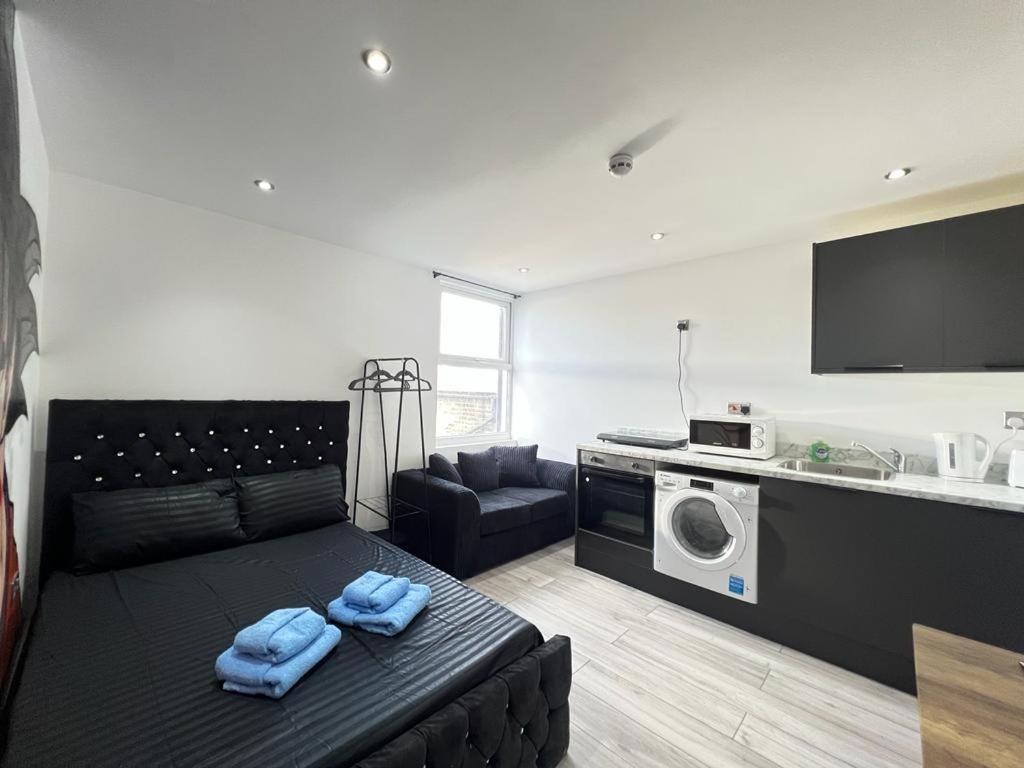 ein Wohnzimmer mit einem Sofa und einer Mikrowelle in der Unterkunft Studio Apartments Central London in London