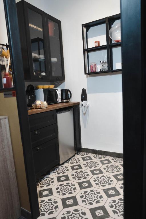 a bathroom with a black cabinet and a tile floor at HomeSparadise Loveroom in Besançon