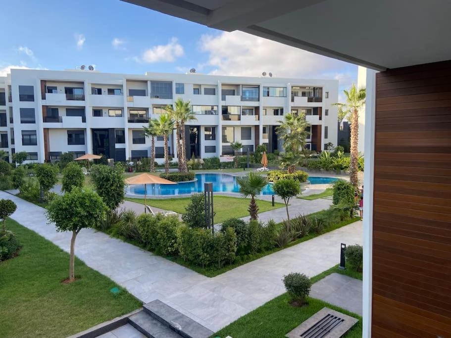 um edifício de apartamentos com piscina e palmeiras em Duplex luxe - Résidence privée - Casablanca/Bouskoura em Bouskoura