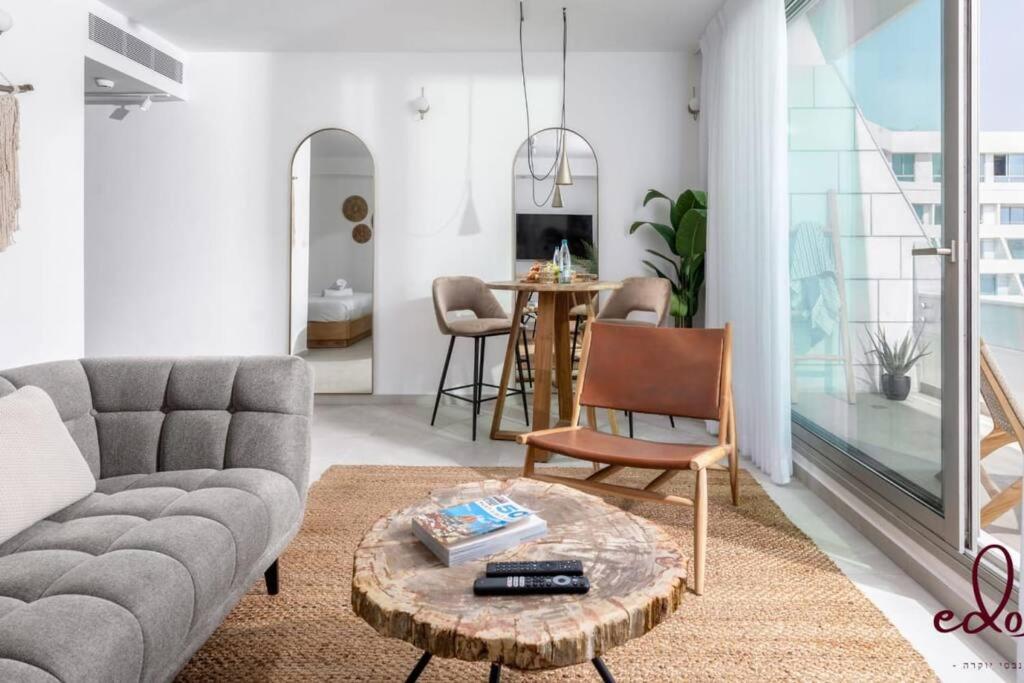 een woonkamer met een bank en een tafel bij דירה מהפנטת במתחם סי סייד 100 מטר מהים - By Edom in Eilat