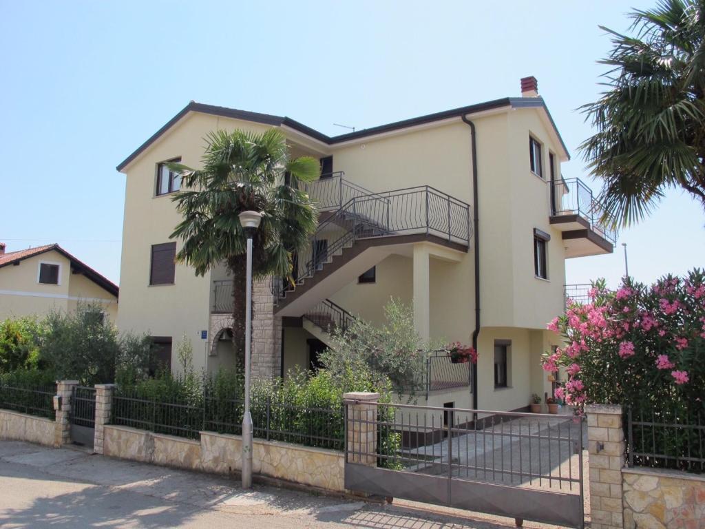 a house with a palm tree in front of it at Apartments Ana in Novigrad Istria