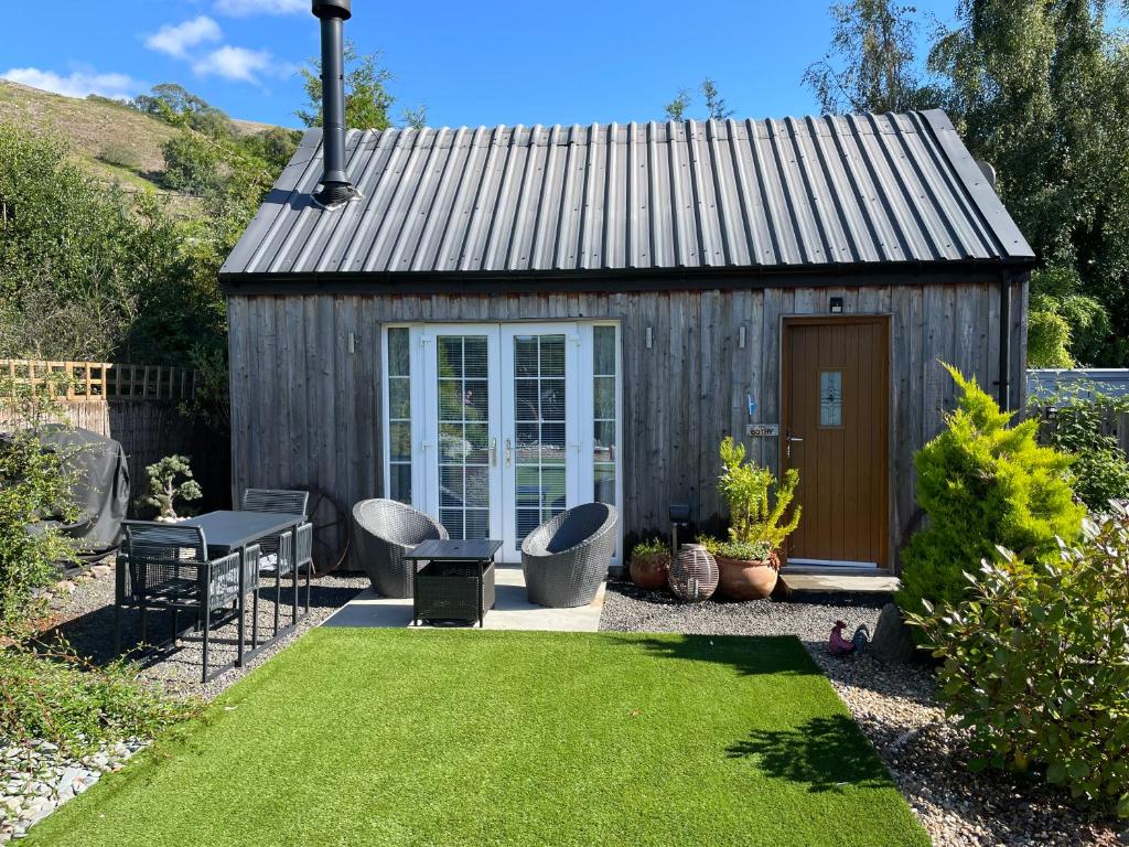 een tuinhuisje met een grasveld bij The Bothy - your unique luxury refuge in Saint Fillans