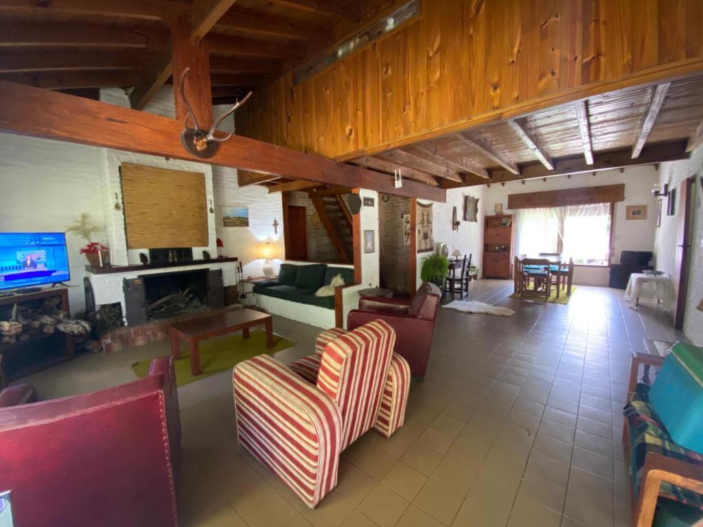Una sala de estar llena de muebles y una chimenea. en Casa Quinta El Refugio, en Villa Gesell