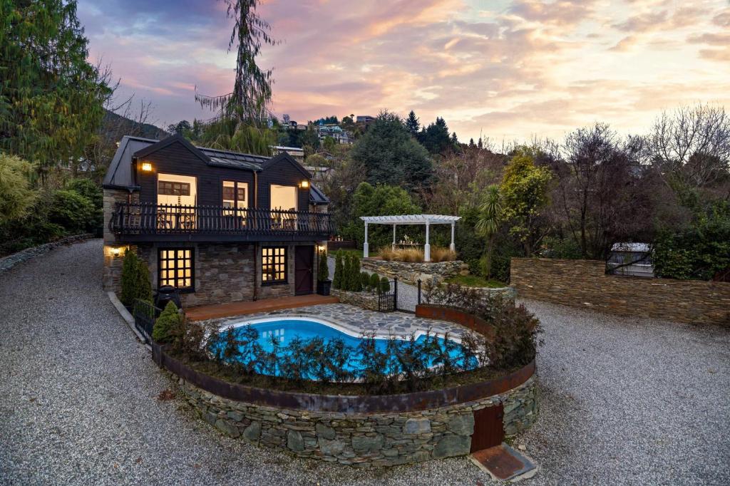a house with a swimming pool in the yard at Alpine Cottage in Queenstown