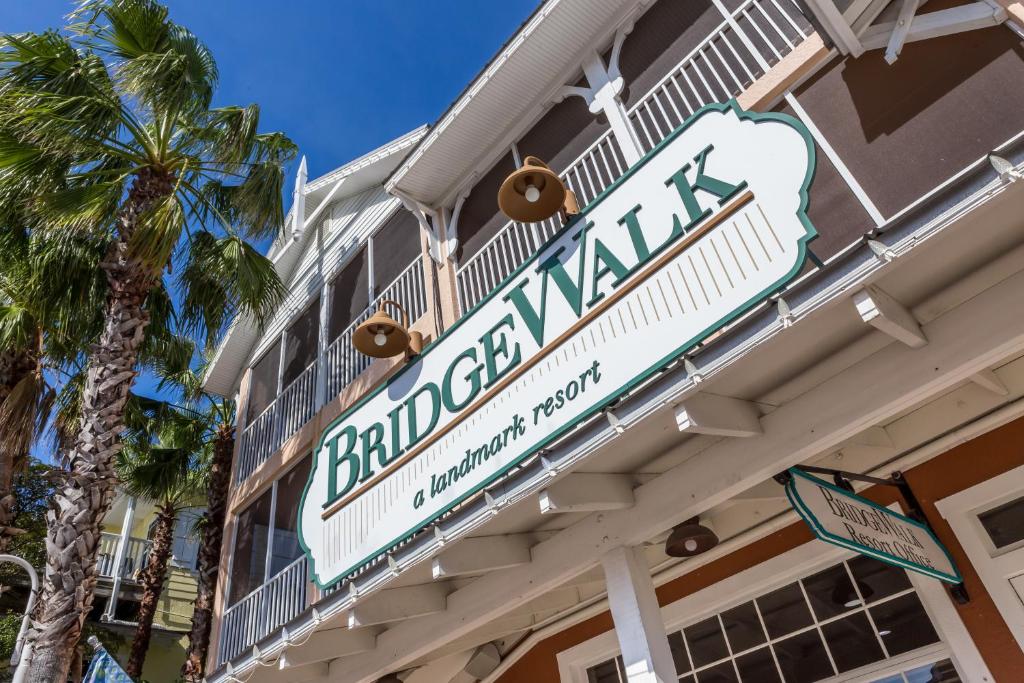 a sign on the side of a building with a palm tree at Bridgewalk, a Landmark Resort in Bradenton Beach