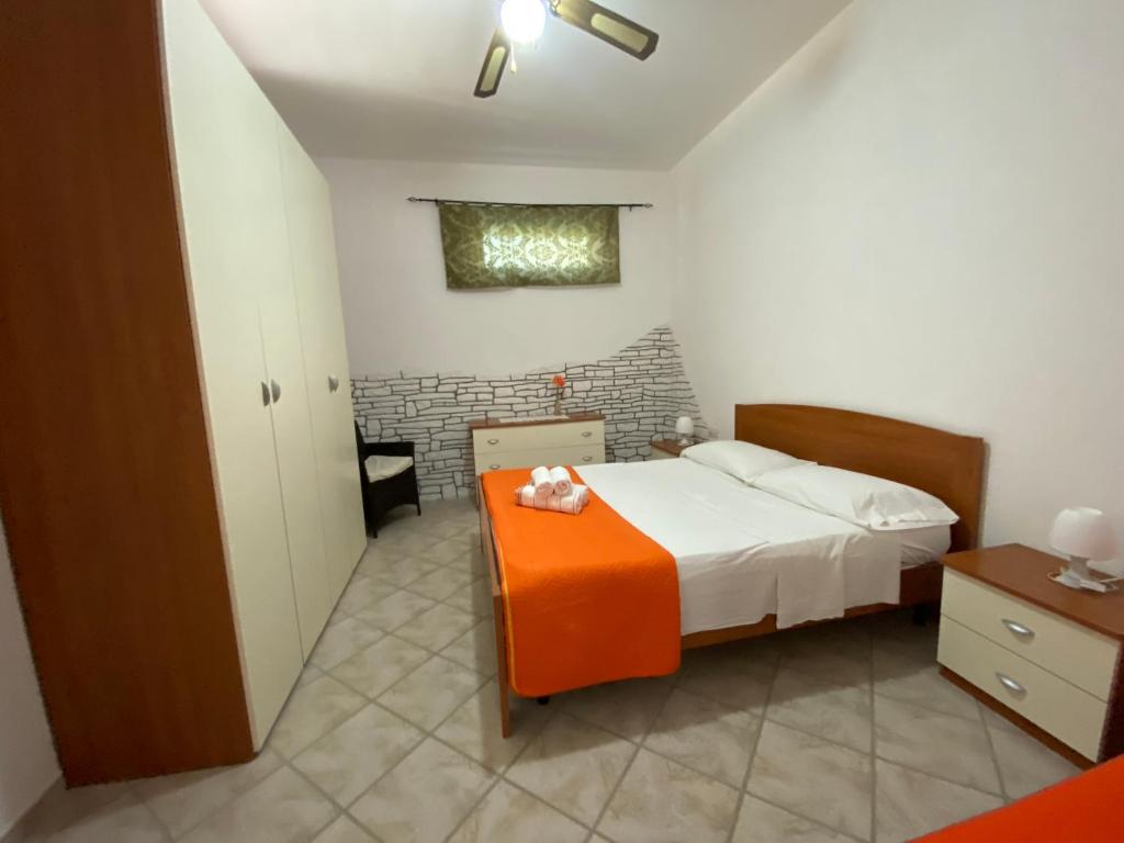 ein Schlafzimmer mit einem Bett mit einem orangenen Stuhl in der Unterkunft CASA VACANZA BORGOROSSO A 70mt DAL MARE in Casa Borgorosso