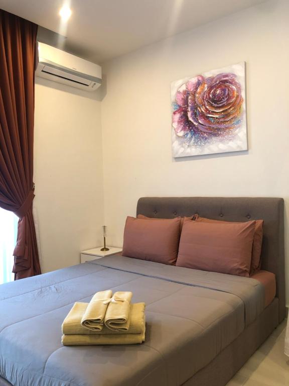 ein Bett mit zwei Schuhpaaren darauf in der Unterkunft Ems Executive Suites Home in Kota Kinabalu