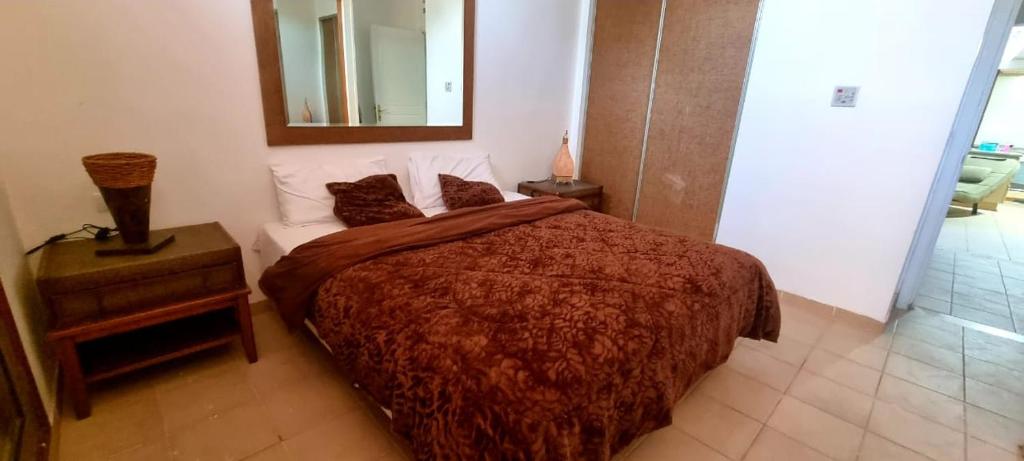 a bedroom with a large bed and a mirror at Flat One room apartment in talabay aqaba in Al Burj