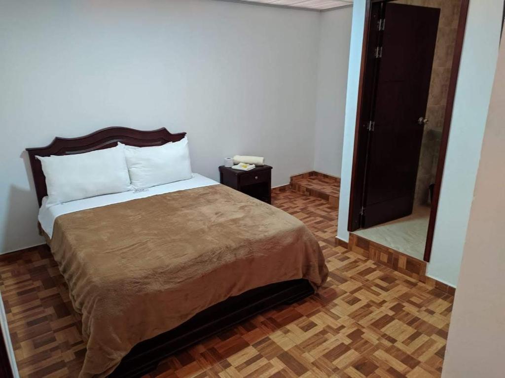 a bedroom with a bed and a door to a bathroom at HOTEL DIAMOND in Gachancipá