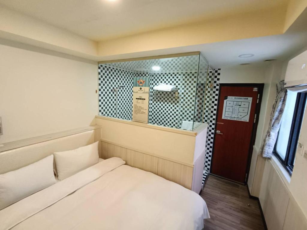 a small room with a bed and a red door at Galaxy Mini Inn in Taipei