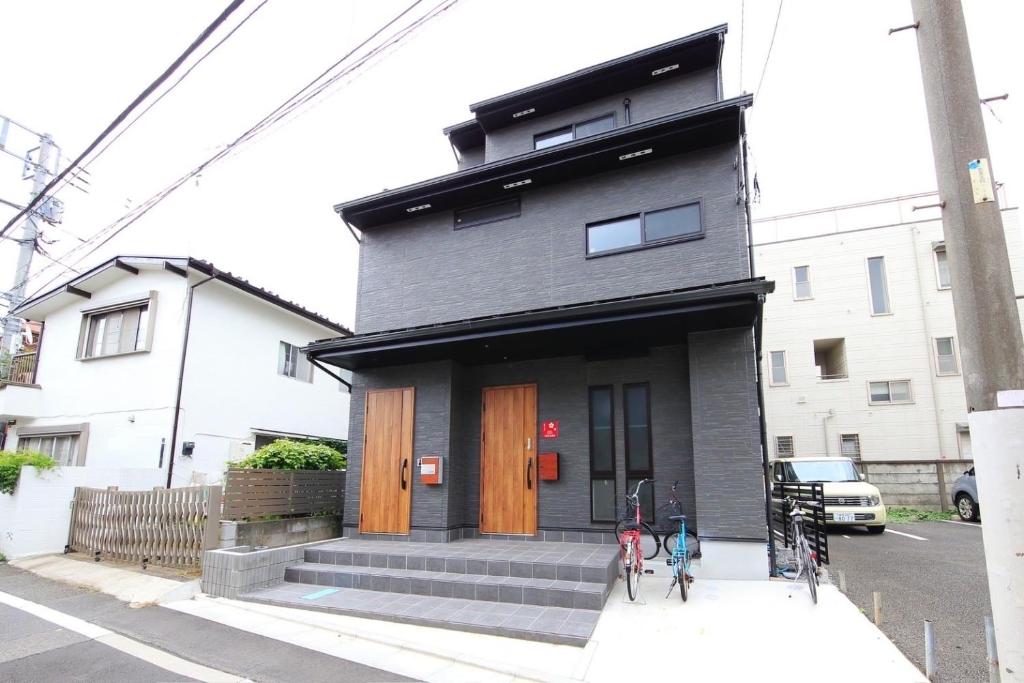 une maison avec deux vélos garés devant elle dans l'établissement COTO Tokyo Sugamo, à Tokyo