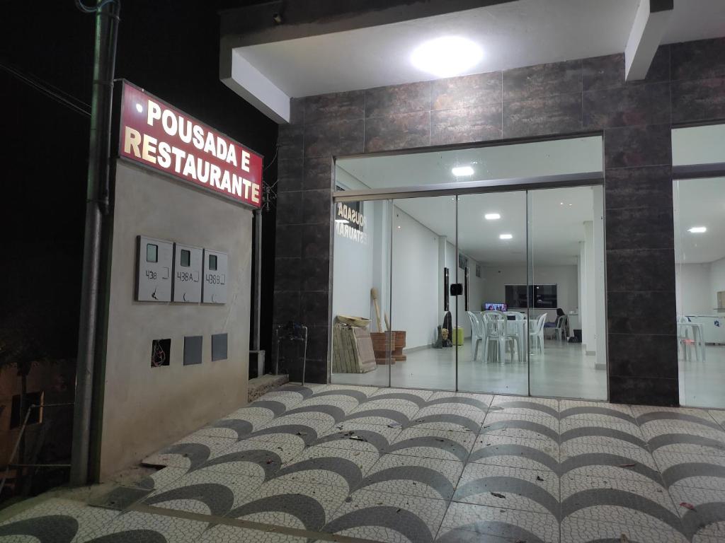 a lobby of a restaurant with a sign on the wall at Pousada Gomes in Itaobim