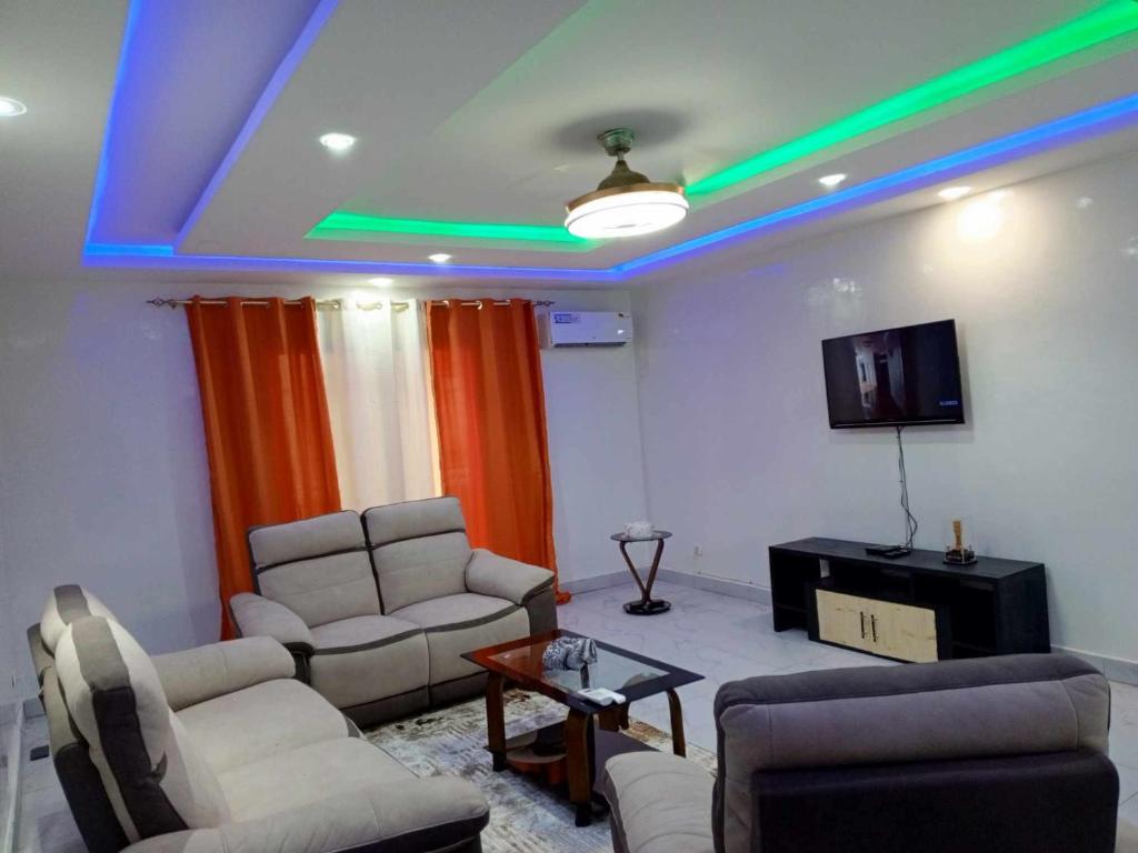 ダカールにあるAppartement 3 chambres toutes climatisées à virageのソファと薄型テレビのあるリビングルーム