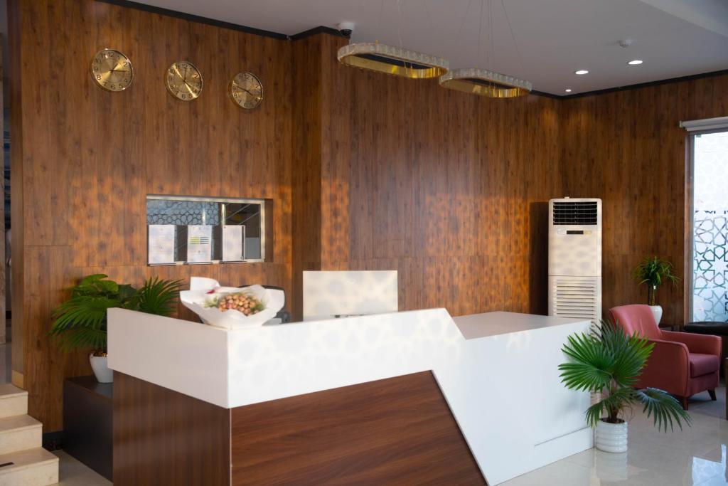 een lobby met een witte bar en houten wanden bij فندق نوفا بارك in Sharurah