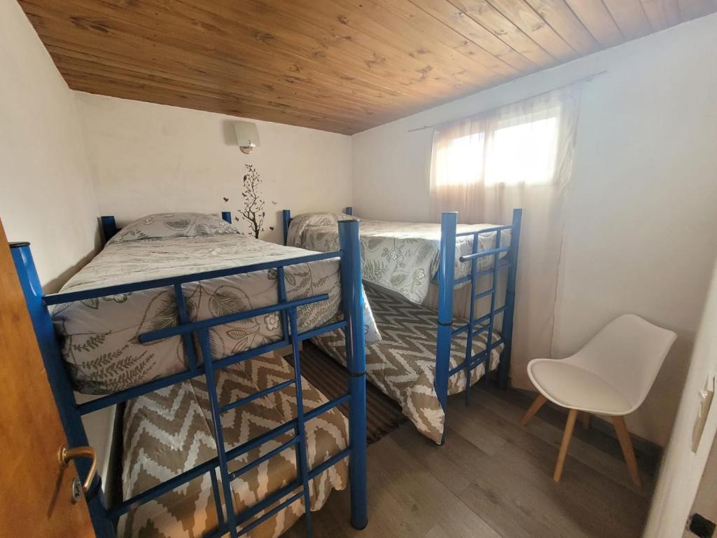 1 dormitorio con 2 literas y 1 silla en RyG Apartments en San Carlos de Bariloche
