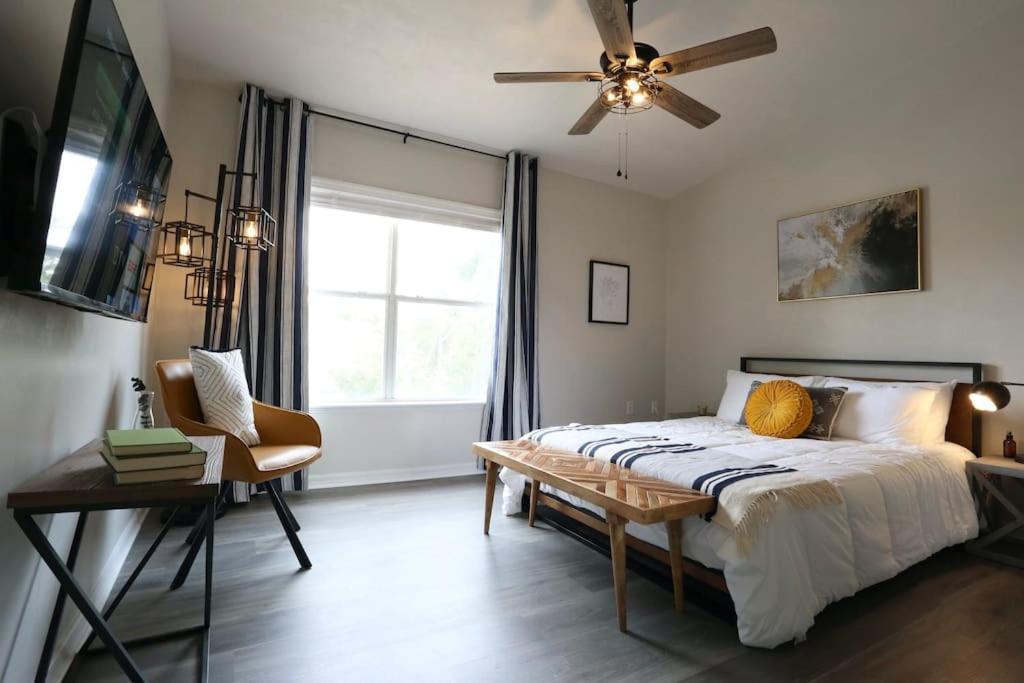 a bedroom with a bed and a ceiling fan at Renovated Modern Industrial Suite 2 BR Condo in Gainesville
