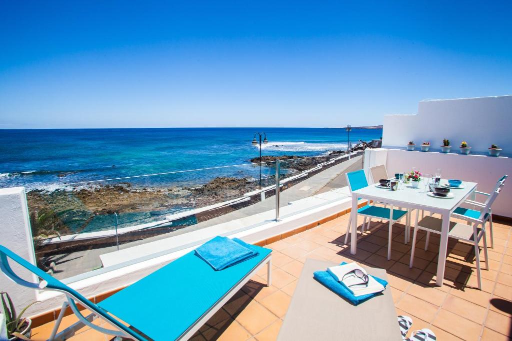 a balcony with a table and chairs and the ocean at Suite Ocean Rooms in Arrieta