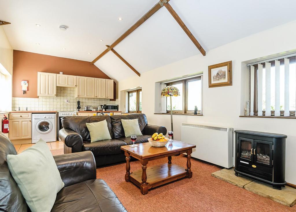a living room with a couch and a table at Exmoor Gate Lodges in Chipstable