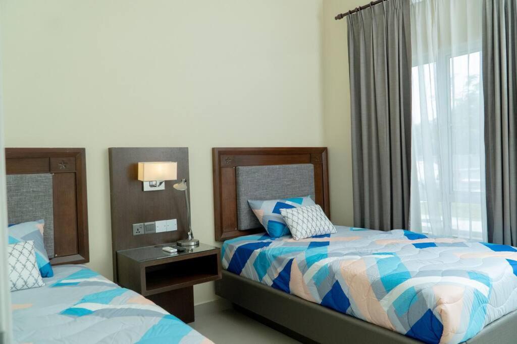 1 Schlafzimmer mit 2 Betten und einem Fenster in der Unterkunft Miro Resthouse by the Pool in Kajang
