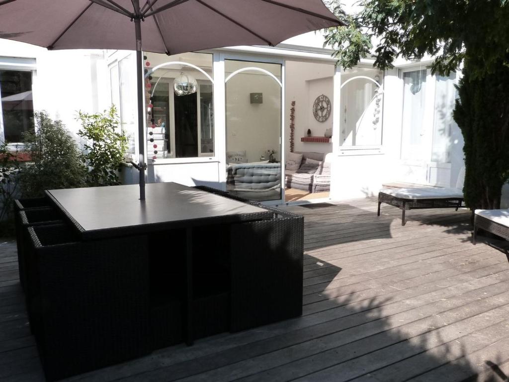 - une table avec un parasol sur la terrasse dans l'établissement Maison La Tranche-sur-Mer, 4 pièces, 6 personnes - FR-1-194-36, à La Tranche-sur-Mer