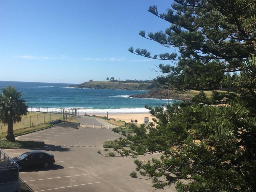 a car parked in a parking lot next to a beach at Kiama beachside apartment in Kiama