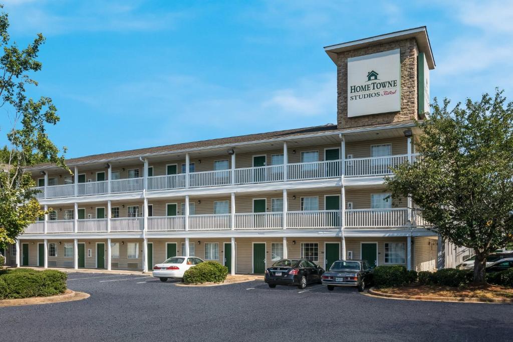 a front view of a hotel with a parking lot at HomeTowne Studios by Red Roof Covington, GA in Covington