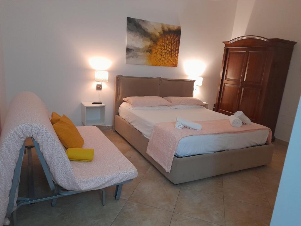 a small bedroom with two beds and a chair at ARISTOCASA in Lecce