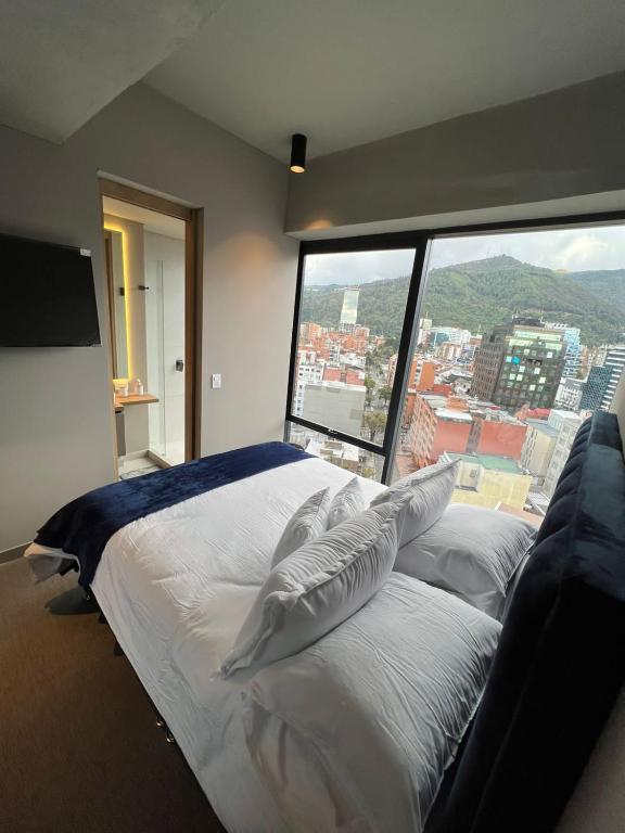 Cama grande en habitación con ventana grande en Espectacular apartamento, en Bogotá