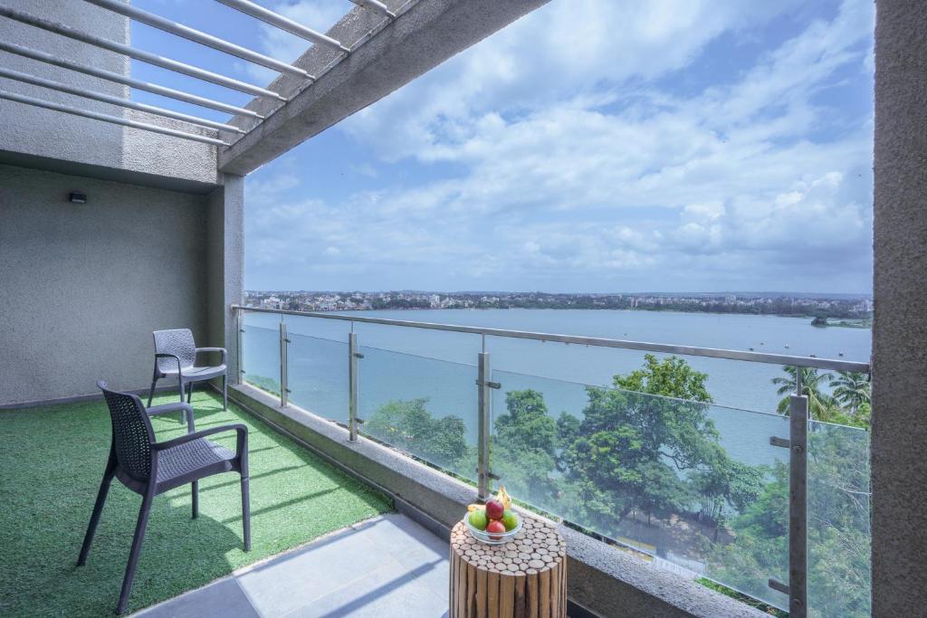 a balcony with a view of the water at Grey Stone - Lakefront PentHouse Family Rooms in Kolhapur