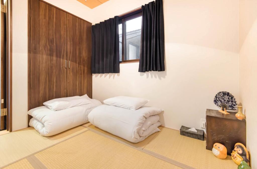 two white bean bags in a room with a window at 桜の宿 高田 provide two free bicycle in Kyoto