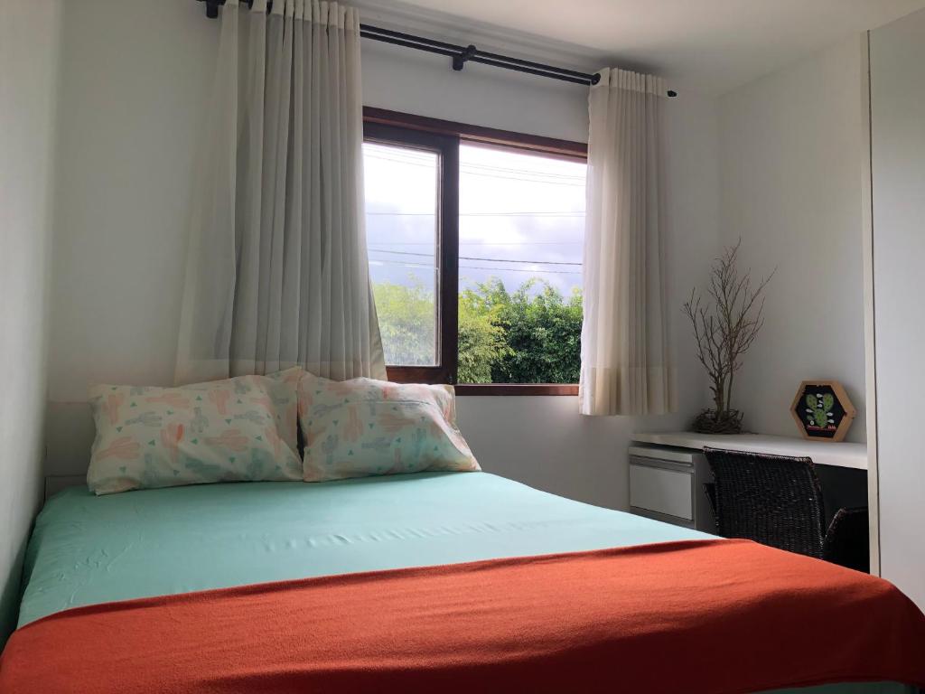 um quarto com uma cama e uma janela grande em Chalé Refidim em Gravatá