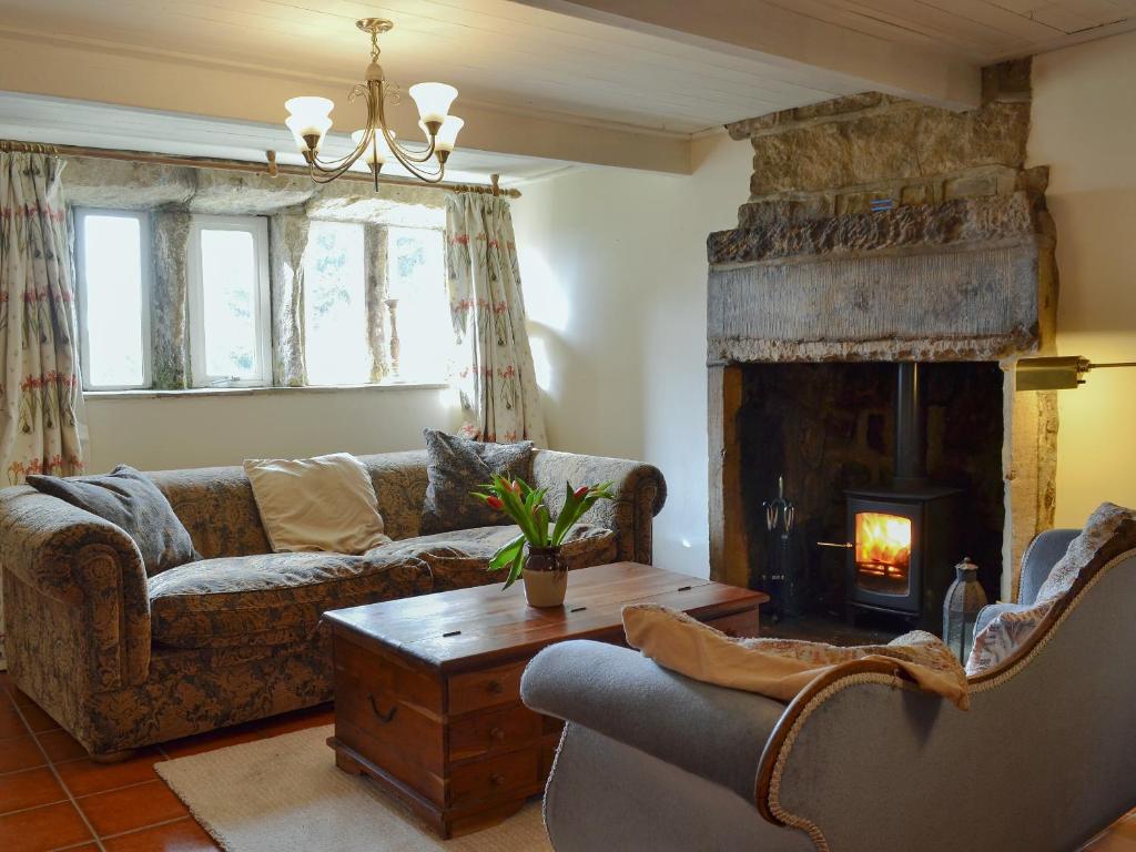 a living room with a couch and a fireplace at Halstead Green Farm in Mytholm