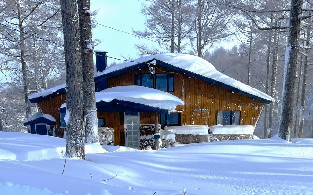 a log cabin with snow on top of it at Japan Snowsports in Iiyama