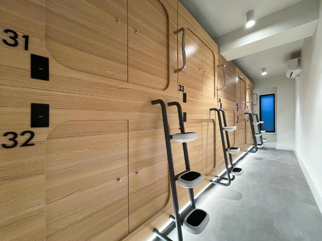 a row of lockers in a gym with wooden walls at Airone Capsule Hotel in Hobart