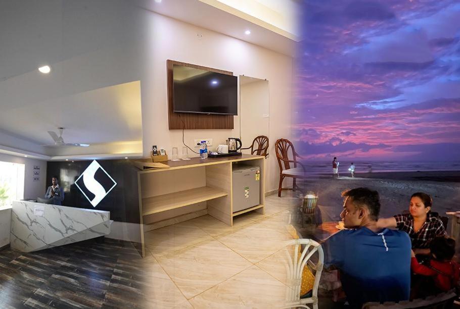 two men sitting in a living room with a television at Sandbanks Beach Resort in Arambol