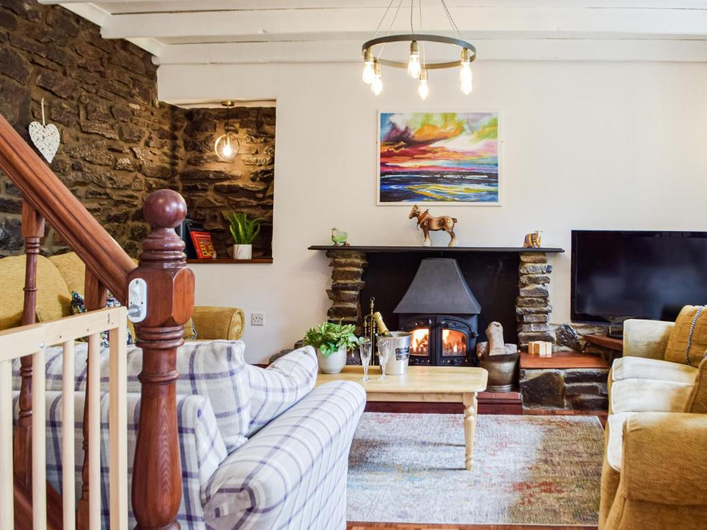 a living room with a couch and a fireplace at Ty Lewis Cottage in Llanelli