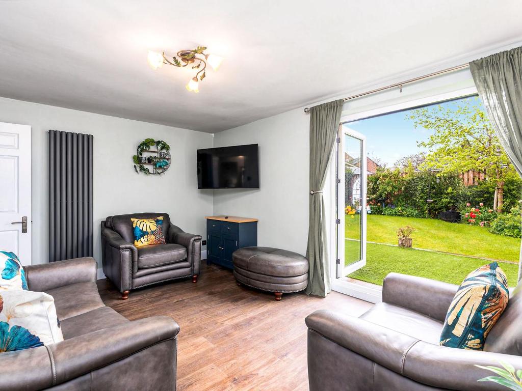 a living room with two couches and a large window at Plum Tree House in Dore