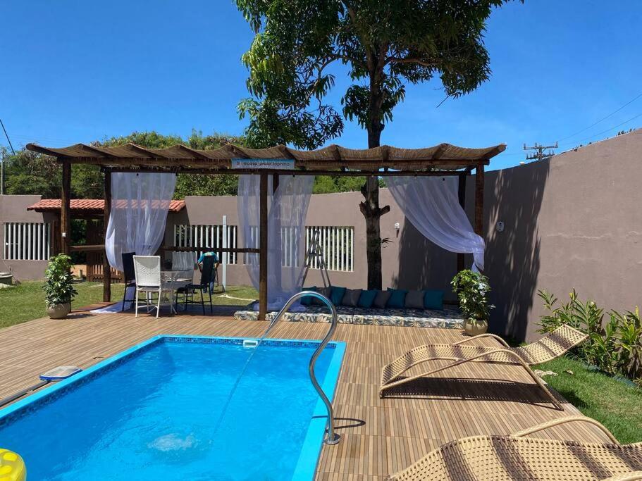 un patio con piscina y cenador en Casa_praia_Laphina - Frente do mar com piscina! en Guarapari