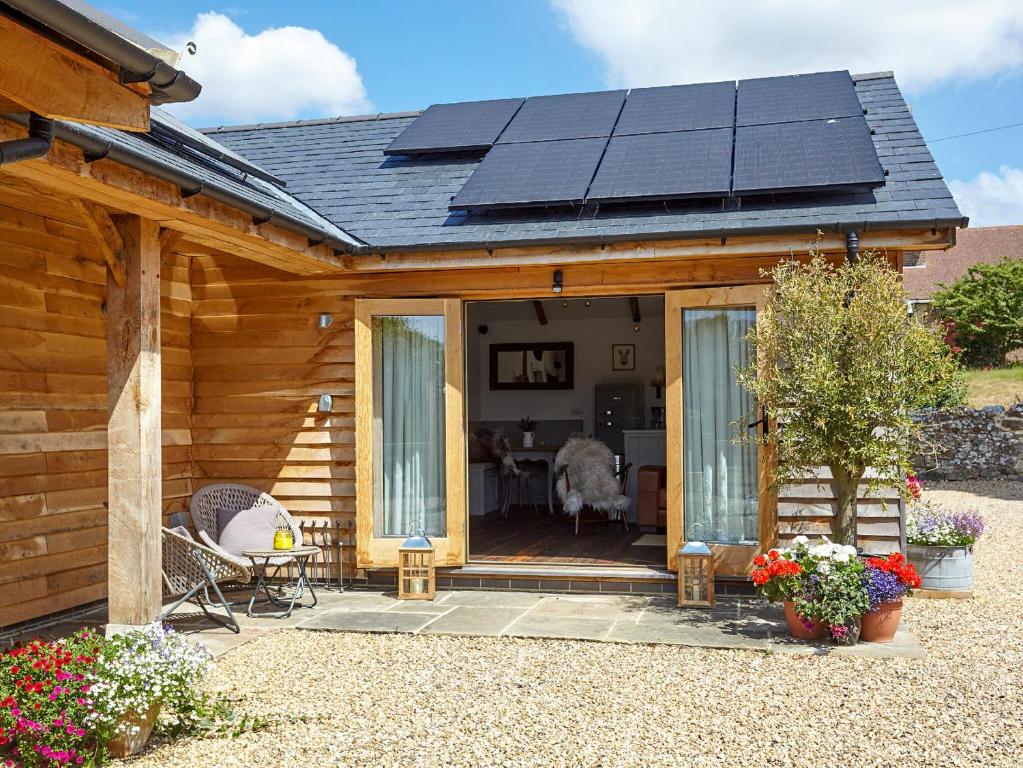 uma casa com painéis solares no telhado em The Barn em Brighstone