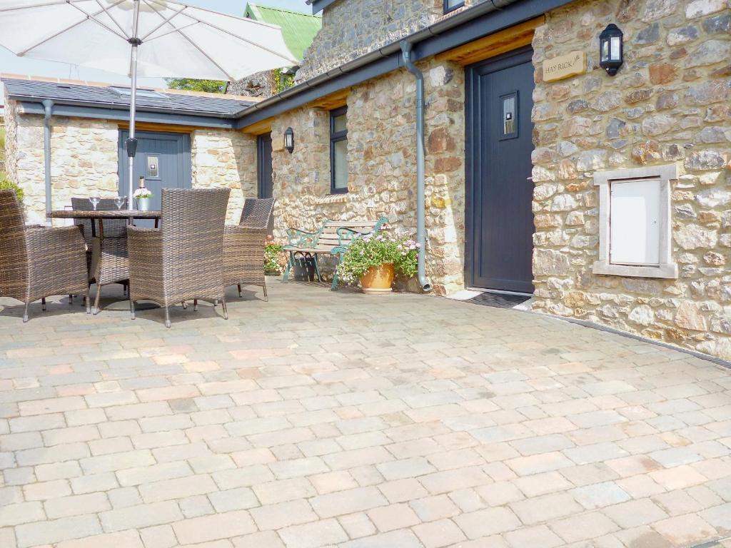 a patio with a table and chairs in front of a building at Hay Rick - Ukc2401 in Luton