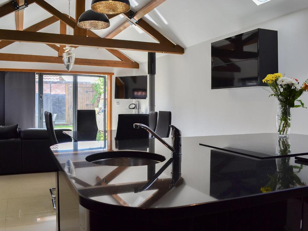 a kitchen with a glass counter top and a table at The Old Stables in South Cave