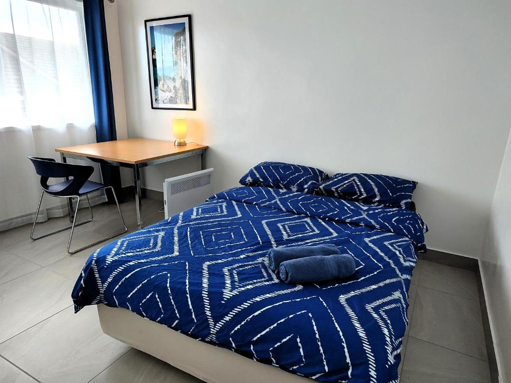 a bedroom with a bed with a blue comforter and a table at PROMO! Near Train Station, FREE WIFI! in Melbourne