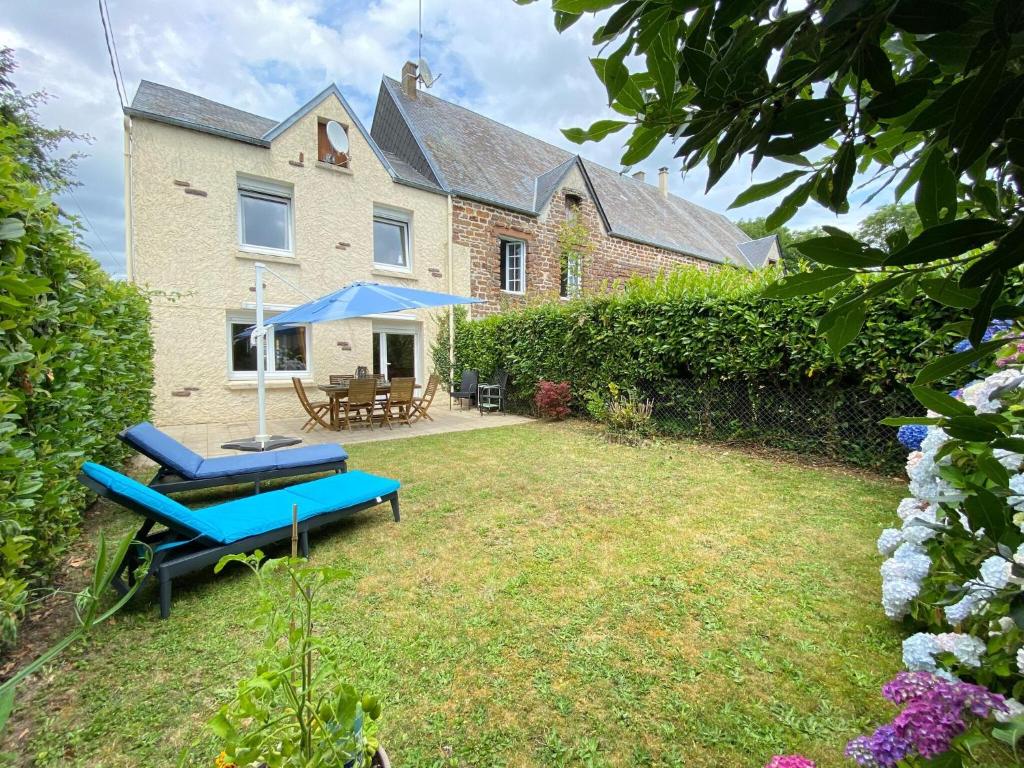 una casa con un patio con un banco y una mesa en Charming, quiet holiday home on the west coast of the Cotentin, en Bréhal