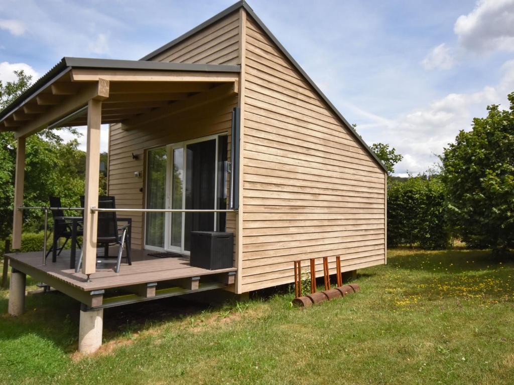 a tiny house with a porch and a deck at Beautiful holiday home in the middle of nature in Berlingen